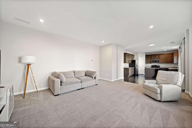 carpeted living area with baseboards, visible vents, and recessed lighting