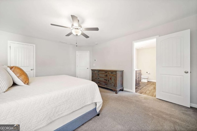 bedroom featuring ceiling fan, baseboards, ensuite bathroom, and light colored carpet