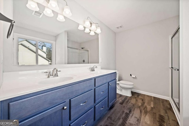 full bath with a shower stall, visible vents, a sink, and wood finished floors