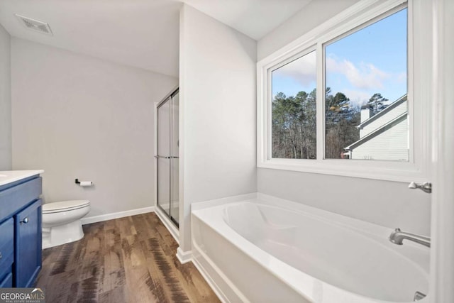 bathroom with visible vents, wood finished floors, vanity, a shower stall, and a bath