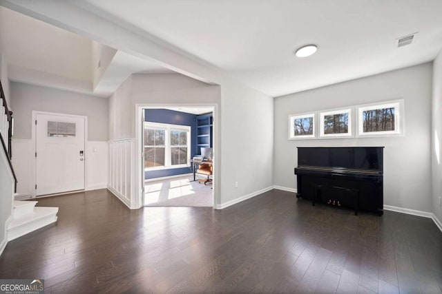 foyer with dark wood-type flooring, visible vents, baseboards, and stairs