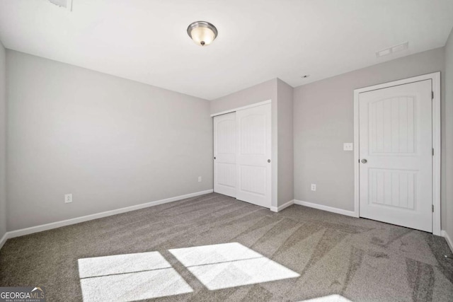 unfurnished bedroom featuring carpet floors, a closet, and baseboards