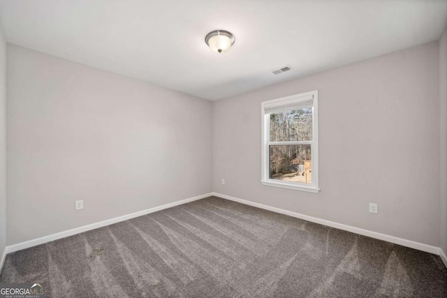 carpeted empty room featuring visible vents and baseboards