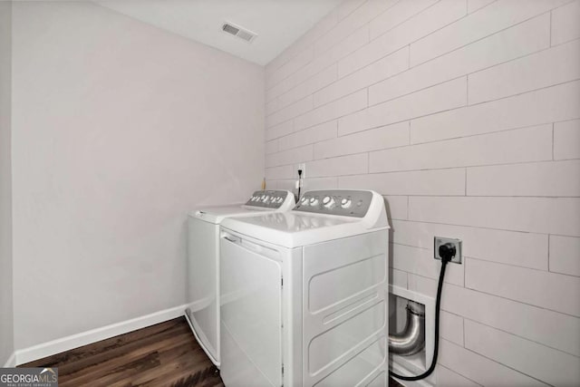 laundry room featuring dark wood-style flooring, washing machine and clothes dryer, visible vents, laundry area, and baseboards