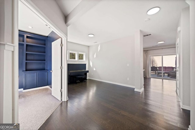 unfurnished living room with plenty of natural light, dark wood-style floors, baseboards, and visible vents