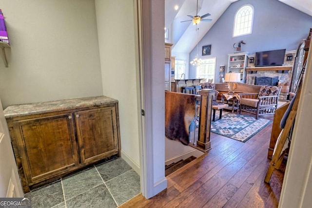 537 Mill Ridge Rd, Hiawassee, GA 30546 - interior space featuring a ceiling fan, dark wood-type flooring, high vaulted ceiling, and a stone fireplace