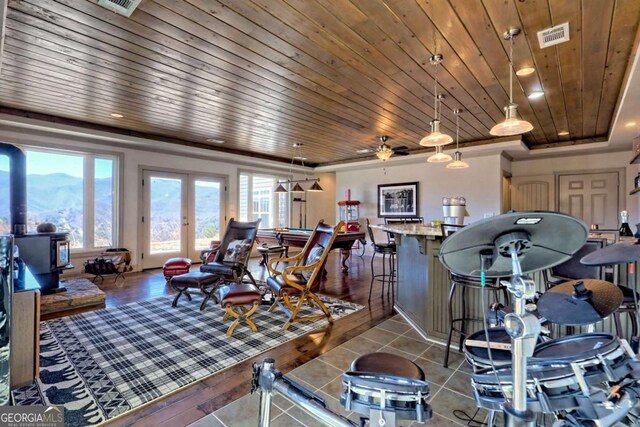 537 Mill Ridge Rd, Hiawassee, GA 30546 - tiled living area featuring french doors, visible vents, a wood stove, a mountain view, and wooden ceiling