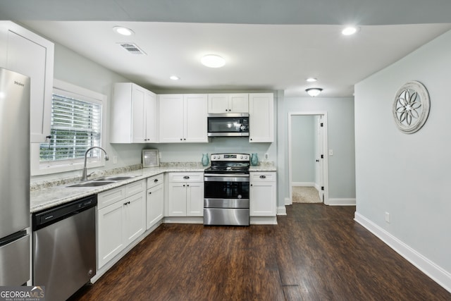 kitchen featuring appliances with stainless steel finishes, white cabinets, a sink, and visible vents