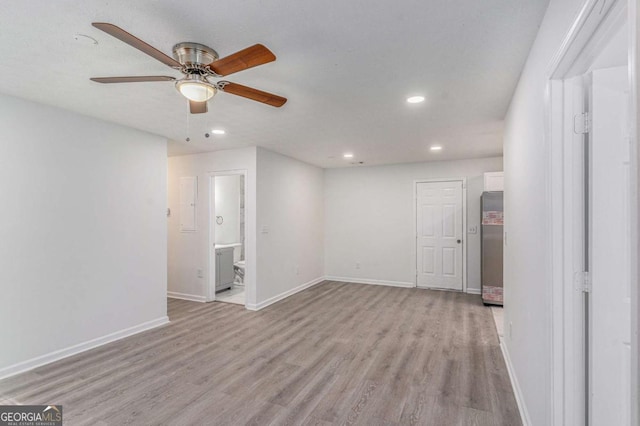 spare room featuring light wood-style flooring, baseboards, a ceiling fan, and recessed lighting