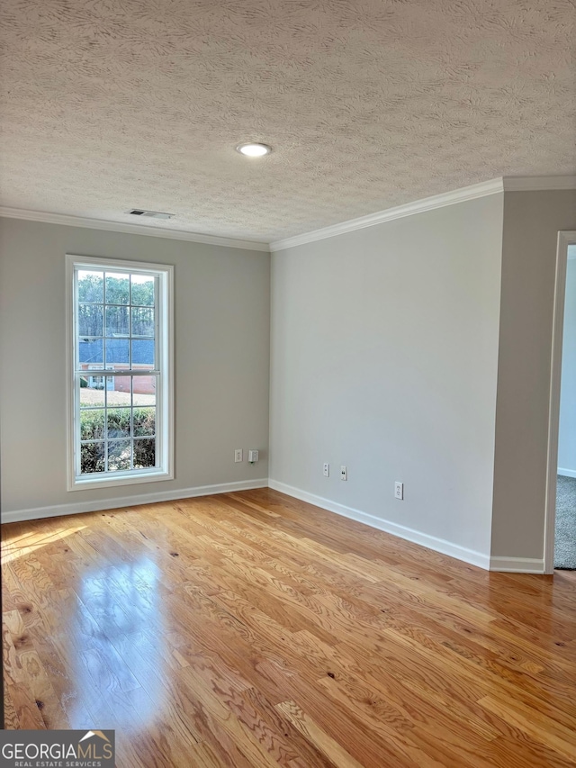 unfurnished room with baseboards, light wood finished floors, a textured ceiling, and crown molding