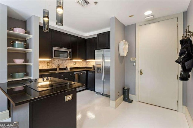 kitchen featuring stainless steel appliances, a sink, visible vents, backsplash, and dark countertops