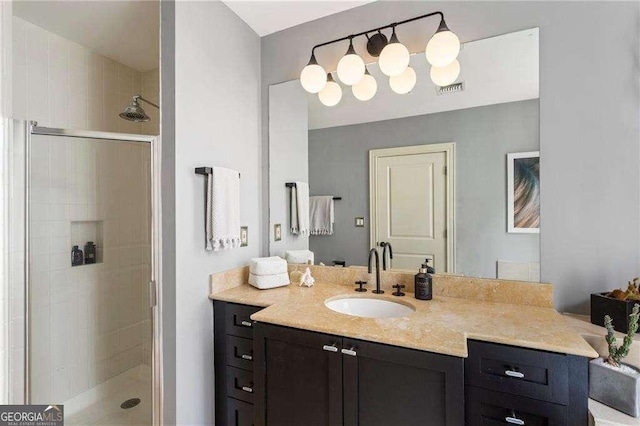 full bathroom featuring visible vents, a tile shower, and vanity