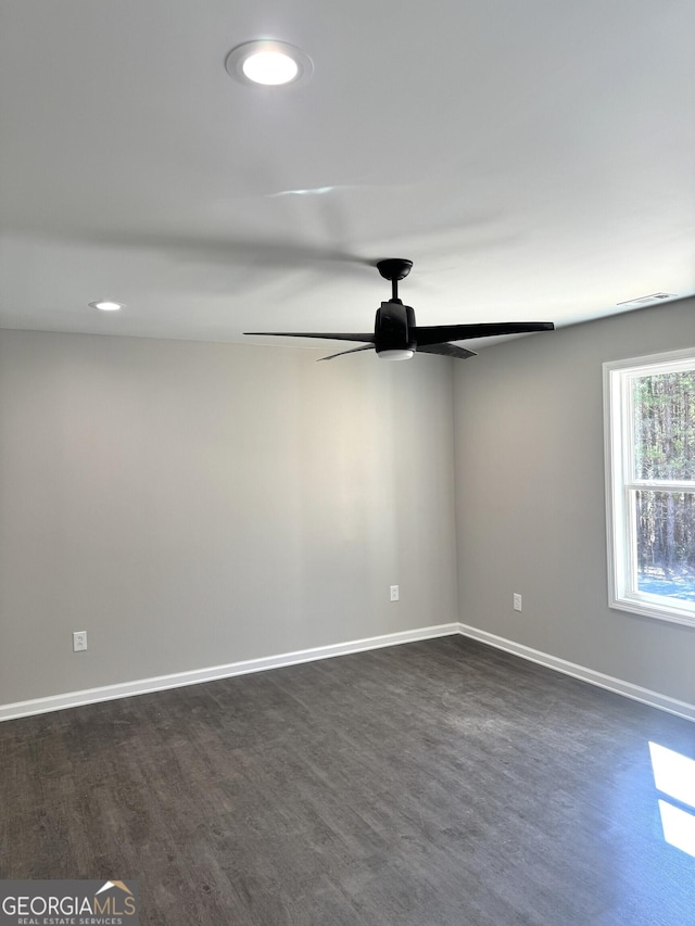 empty room featuring dark wood finished floors, recessed lighting, visible vents, a ceiling fan, and baseboards