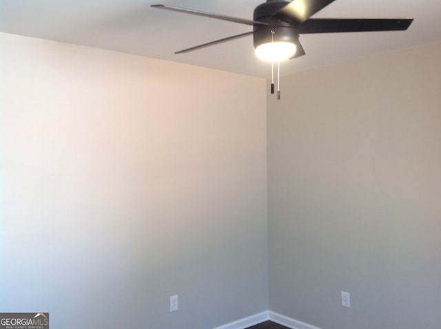 spare room featuring a ceiling fan and baseboards