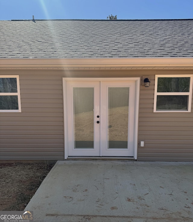 property entrance featuring a shingled roof and french doors