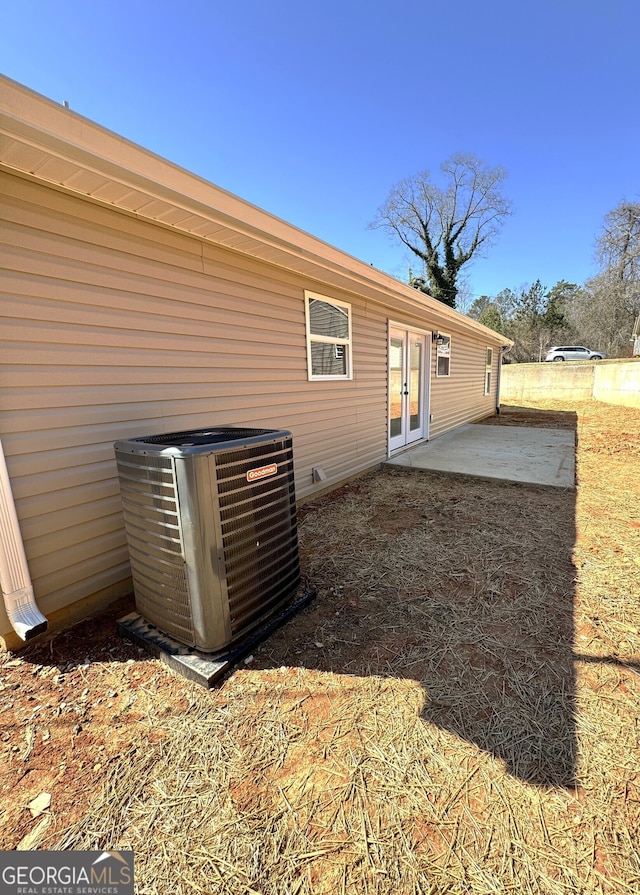 rear view of house with central AC, french doors, and a patio area