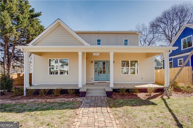 bungalow with a porch, board and batten siding, and fence