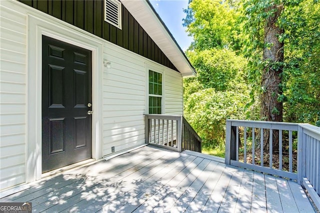 property entrance featuring board and batten siding and a deck