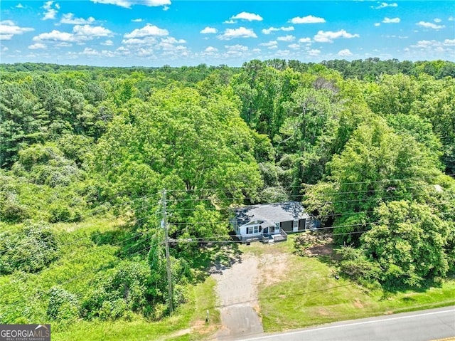 birds eye view of property featuring a view of trees