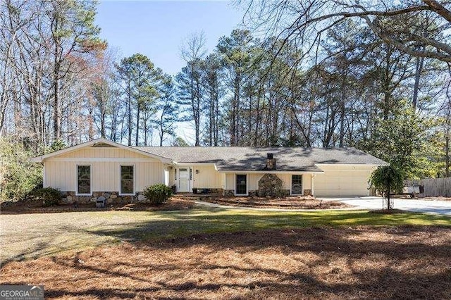 ranch-style house featuring an attached garage, driveway, and a front lawn