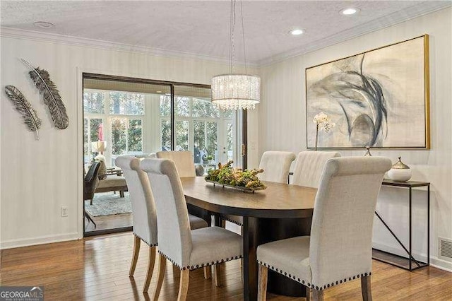 dining area with ornamental molding, visible vents, baseboards, and wood finished floors