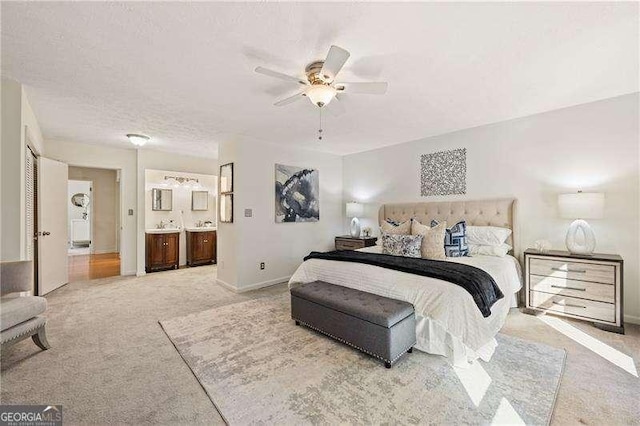 bedroom featuring a textured ceiling, carpet floors, a ceiling fan, baseboards, and ensuite bath