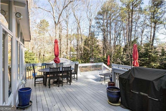 deck with outdoor dining area and area for grilling