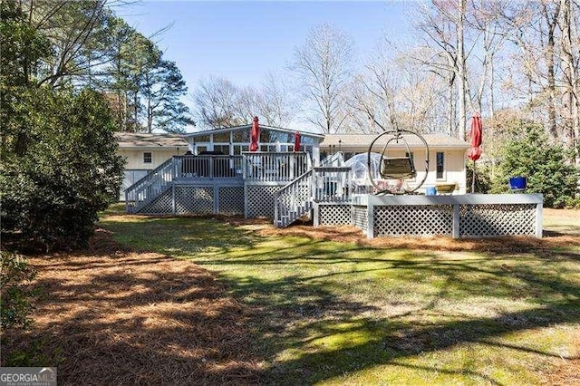 rear view of house with a deck, stairway, and a lawn