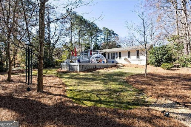 view of yard with a sunroom and a wooden deck