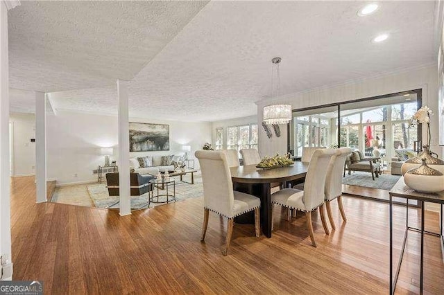 dining area with recessed lighting, a notable chandelier, a textured ceiling, and wood finished floors