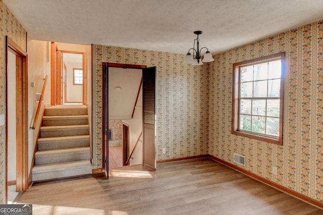 123 Creek Cir, Stockbridge, GA 30281 - unfurnished dining area with baseboards, wood finished floors, visible vents, and wallpapered walls