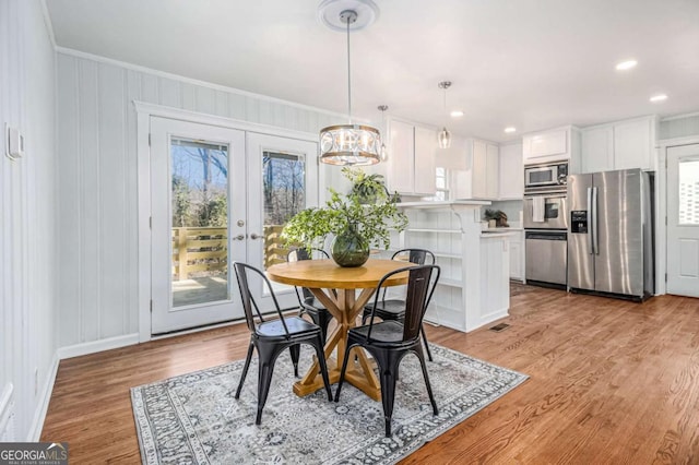 dining room with visible vents, crown molding, french doors, light wood-type flooring, and recessed lighting