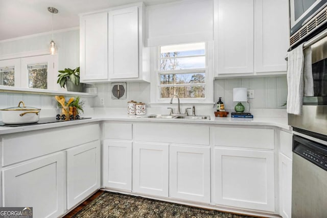 kitchen with appliances with stainless steel finishes, a sink, and white cabinetry