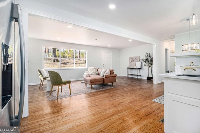 living area with light wood finished floors, baseboards, and recessed lighting