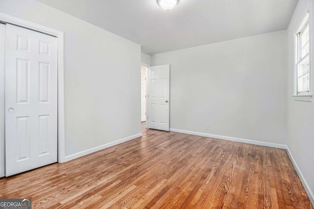 unfurnished bedroom featuring wood finished floors and baseboards