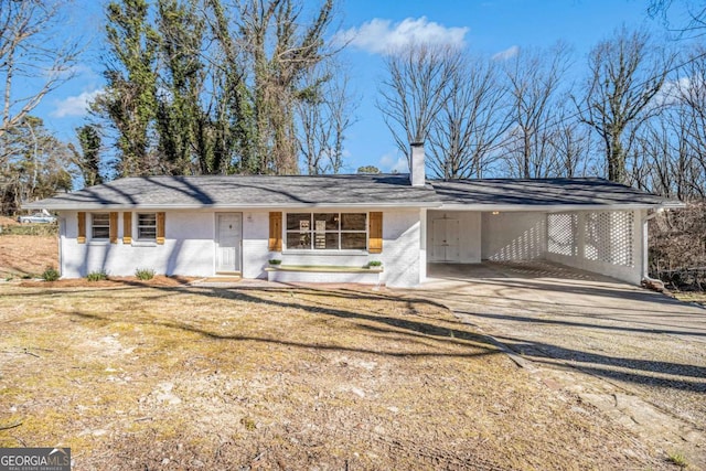 view of front of property with driveway, brick siding, a front lawn, and an attached carport