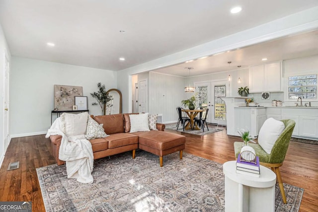 living area with recessed lighting, visible vents, baseboards, and wood finished floors