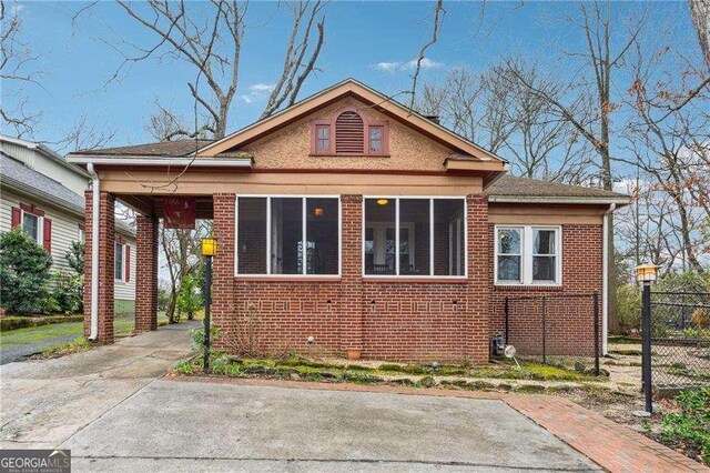 view of front facade featuring brick siding and fence