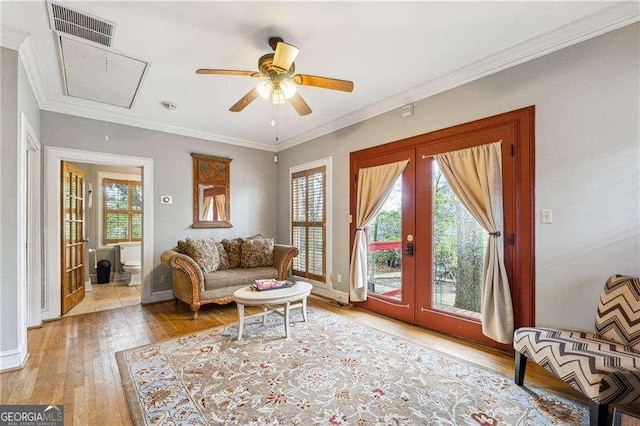 living area featuring visible vents, crown molding, attic access, french doors, and wood finished floors