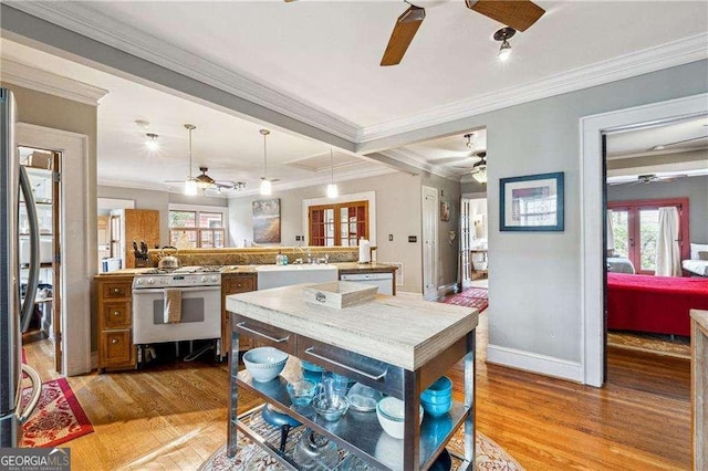 kitchen featuring crown molding, white appliances, light wood finished floors, and pendant lighting