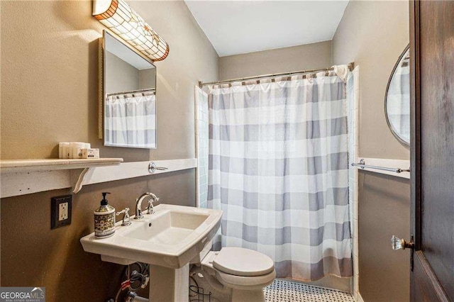 full bath with toilet and a shower with curtain