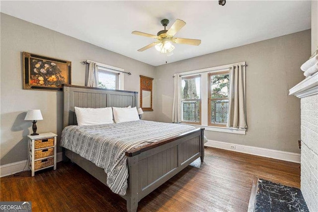 bedroom featuring multiple windows, wood finished floors, baseboards, and ceiling fan