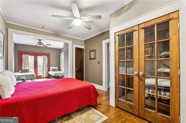 bedroom featuring crown molding, ceiling fan, baseboards, french doors, and wood finished floors