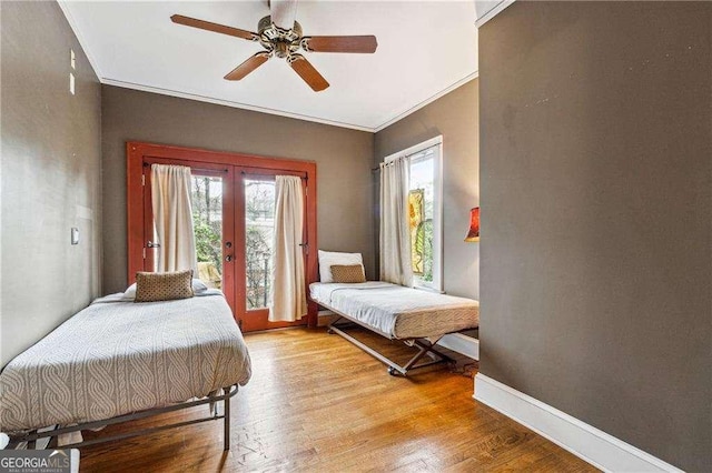 bedroom with light wood-type flooring, french doors, baseboards, and access to exterior