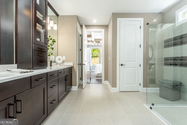 ensuite bathroom featuring double vanity, ensuite bath, a tile shower, and baseboards