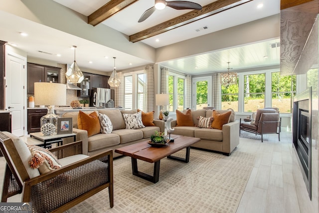 living area featuring visible vents, beamed ceiling, light wood-style flooring, and recessed lighting