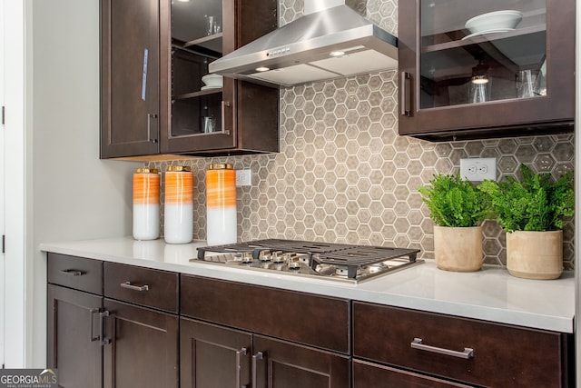 kitchen with wall chimney exhaust hood, light countertops, and dark brown cabinetry