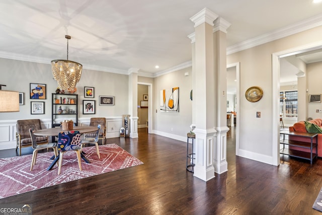 dining room with crown molding, ornate columns, and wood finished floors