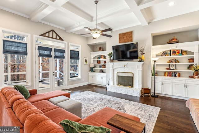 living area featuring dark wood-style floors, built in shelves, a fireplace, and coffered ceiling