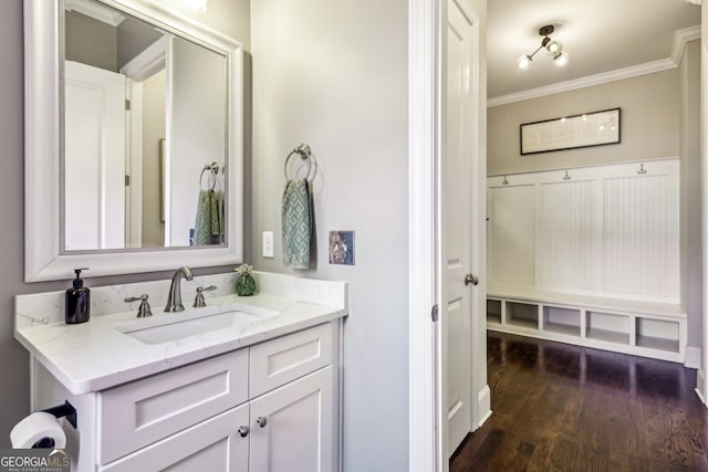 bathroom with ornamental molding, wood finished floors, and vanity